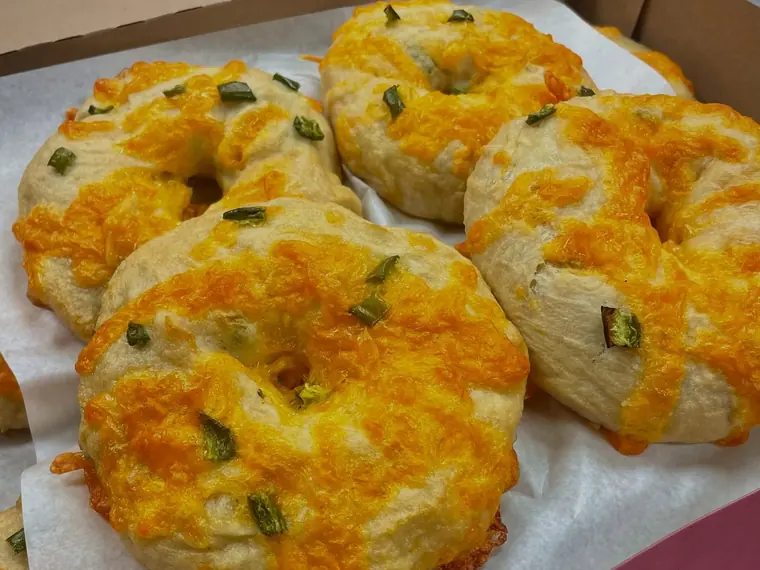 A box of golden bagels topped with melted cheddar and jalape&ntilde;o