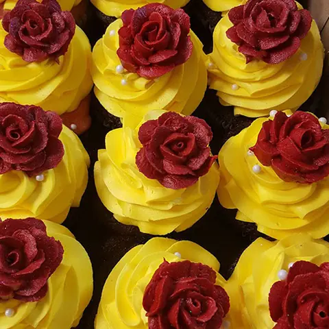 Yellow cupcakes topped with red roses