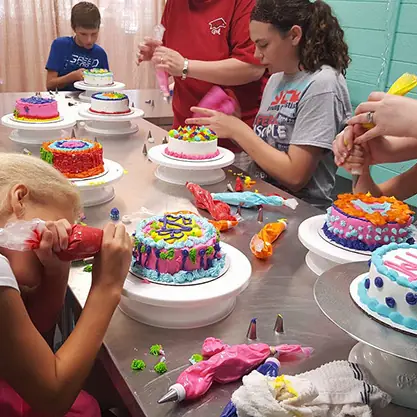 Kids piping icing onto their cakes