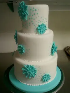 White cake with teal sugar flowers
