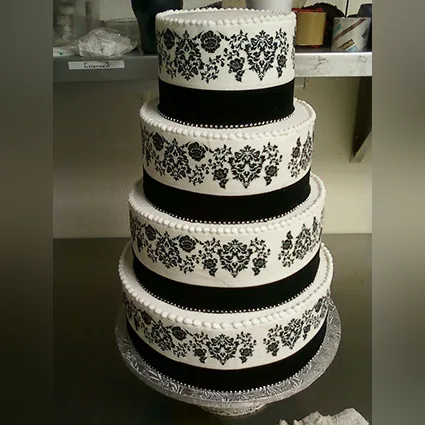 A four-tier black and white damask wedding cake with pearl trim